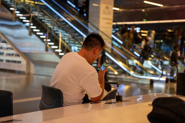 Adult using smartphone in modern airport terminal.jpg