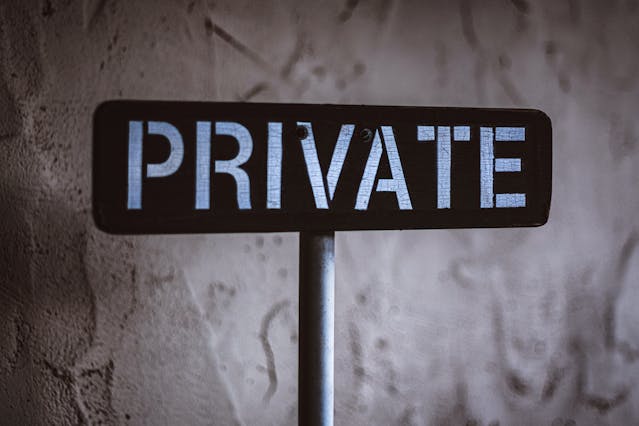 Black and White Wooden Sign Behind White Concrete.jpg