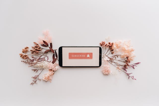 Flat Lay of Dried Flowers and Mobile Phone with Subscribe text