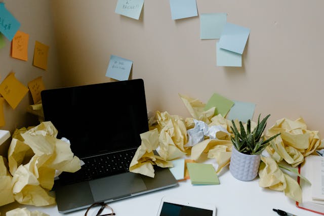 Laptop and Crumpled Papers on a Table