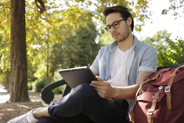 Man in White Dress Shirt and Black Pants Sitting on Bench