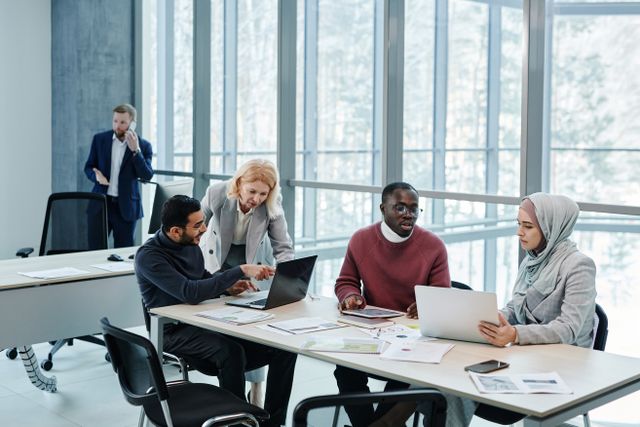 Multicultural group of professionals discussing ideas in a bright, modern office setting