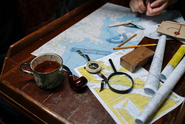 Overhead view of navigation tools with maps, compass, and coffee cup..jpg