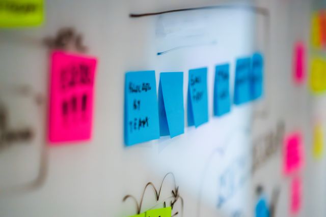 Sticky notes on a whiteboard during a creative brainstorming session in an office