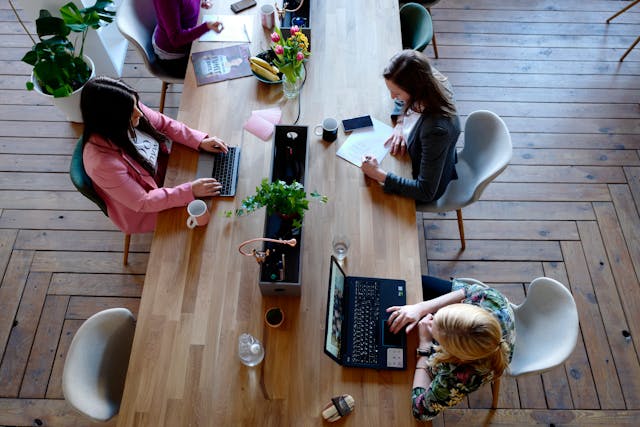 Three woman sitting infront of a table - koofr blog cloud storage for business